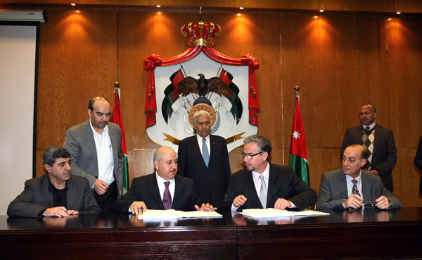 Water Minister Hazem Nasser signs a project agreement with the French Development Agency in the presence of Prime Minister Abdullah Ensour on Wednesday (Petra photo)